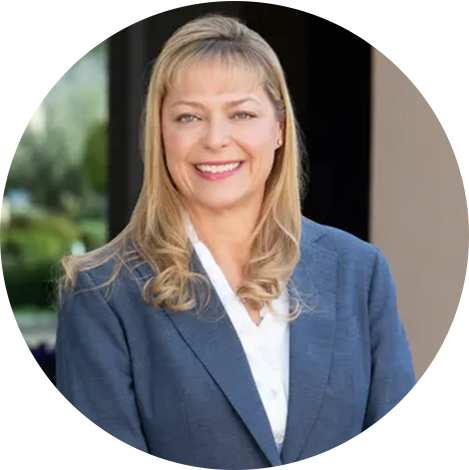 A woman in a suit and tie smiling for the camera.
