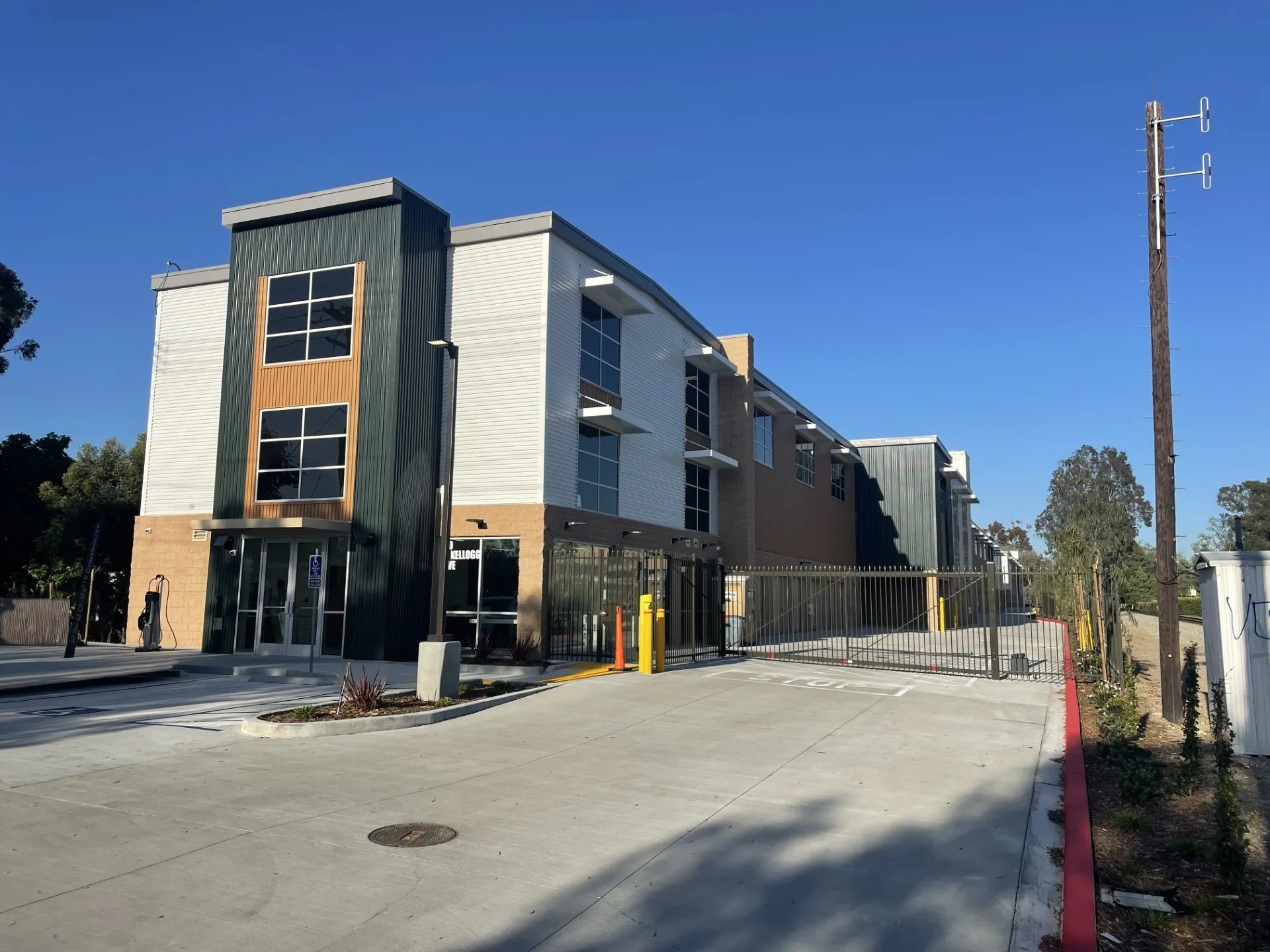 Modern building with gated entrance and driveway.