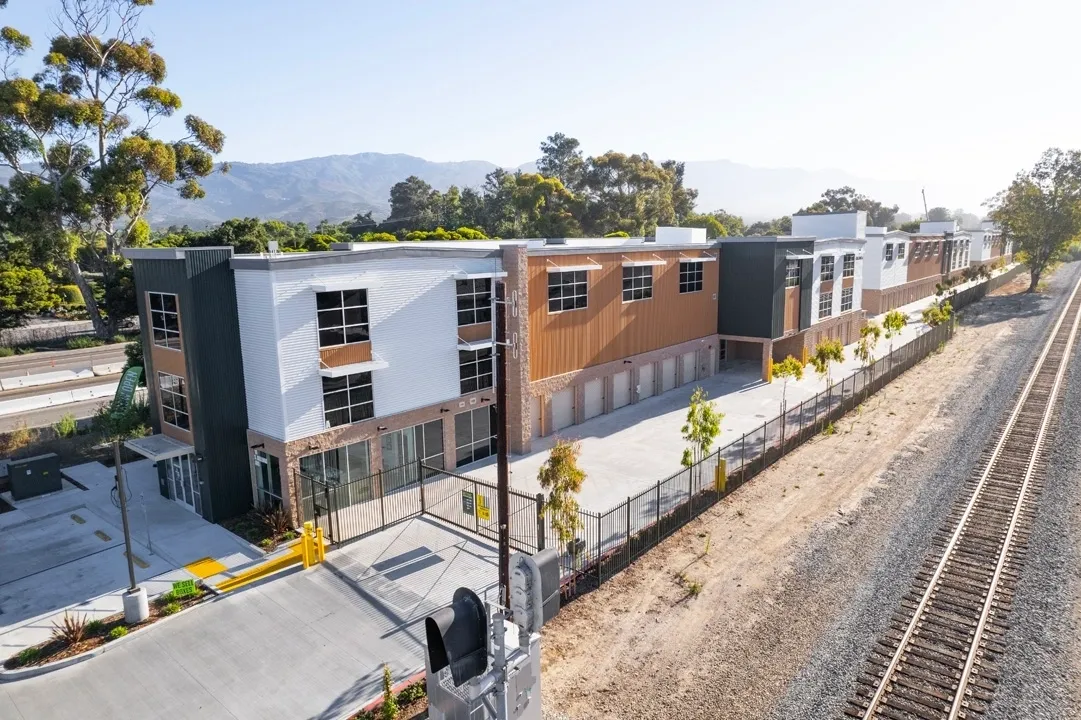 Modern commercial building beside railway tracks.