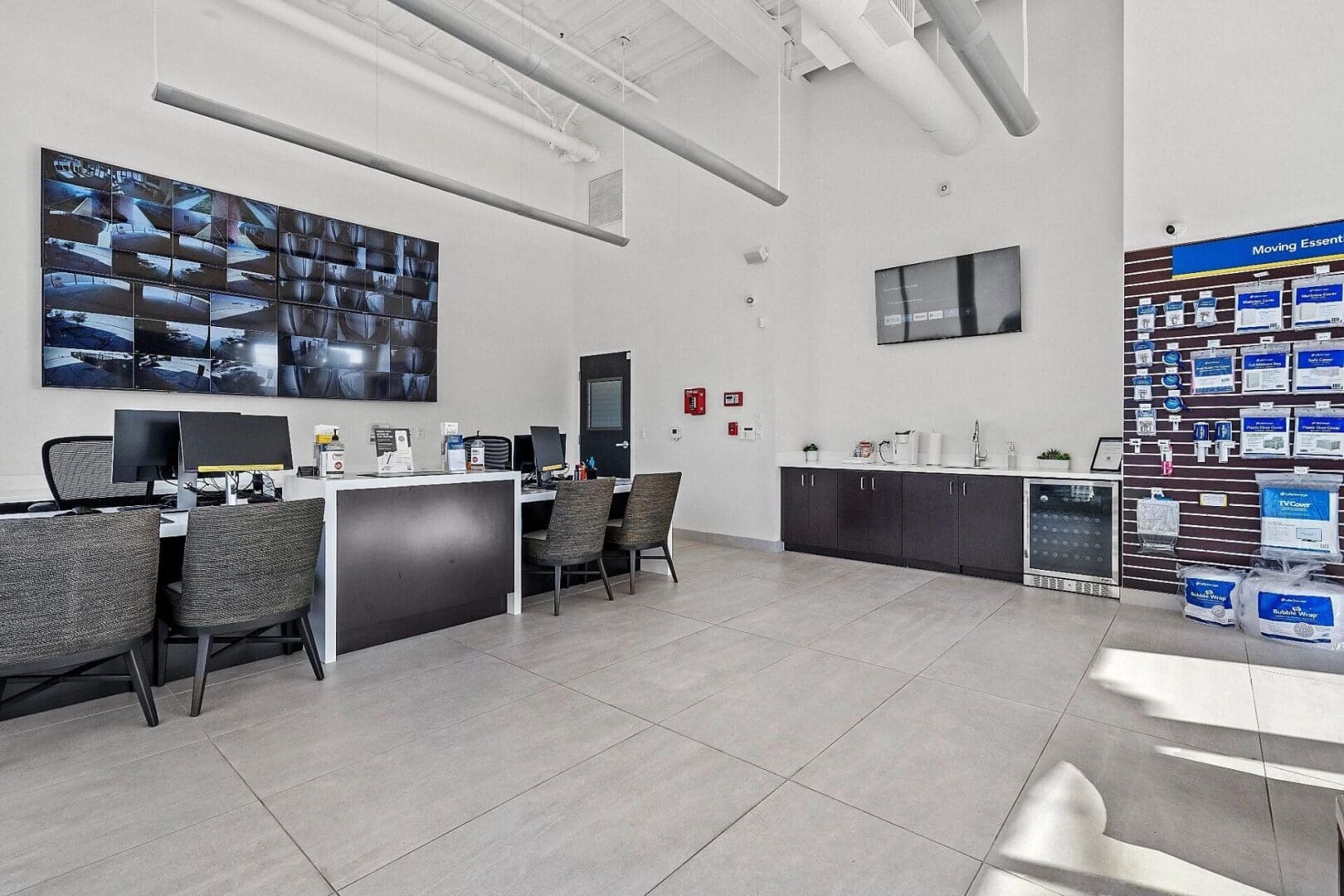 Modern office space with surveillance monitors.